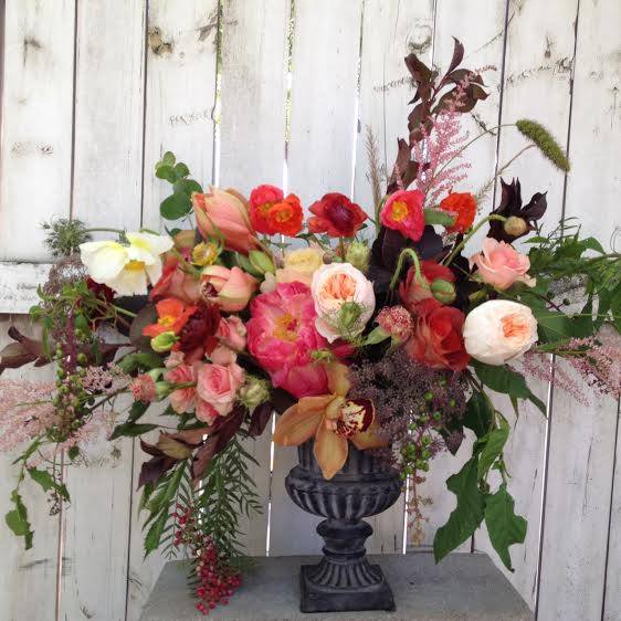 Mixed bouquet in a dark urn vase with pink, red, white, and peach blooms