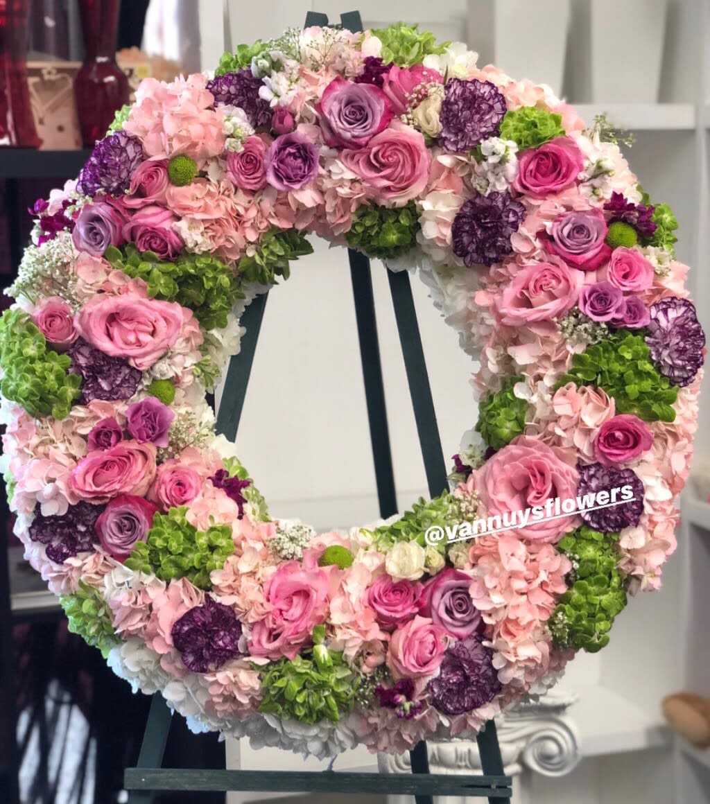 Large wreath of pink and purple roses and hydrangeas on a stand