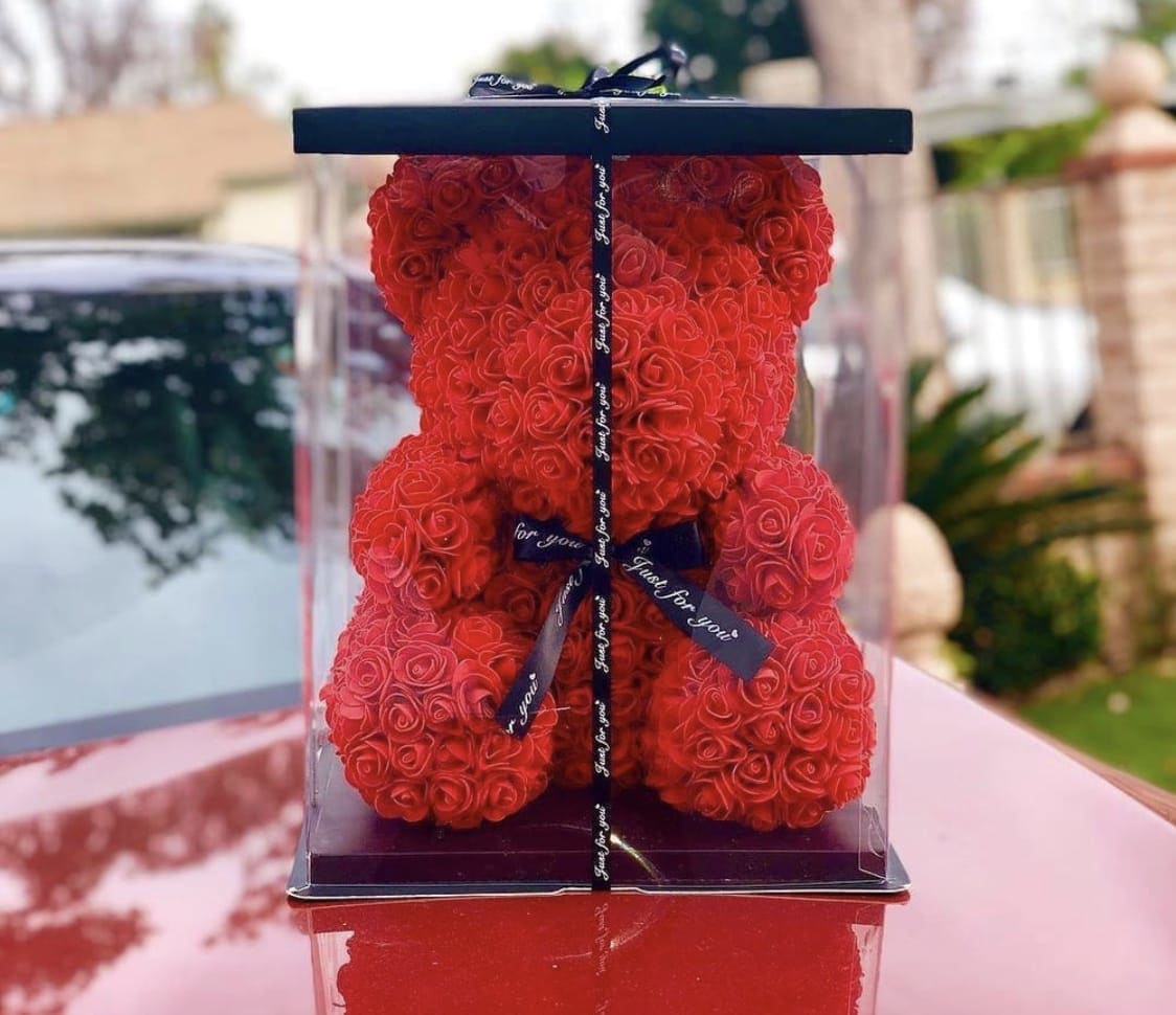 Red rose teddy bear in a clear display box with black base and ribbon