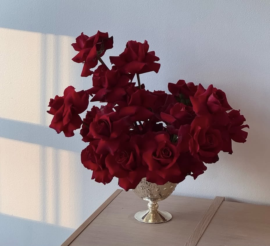 Red roses arranged in a decorative silver vase