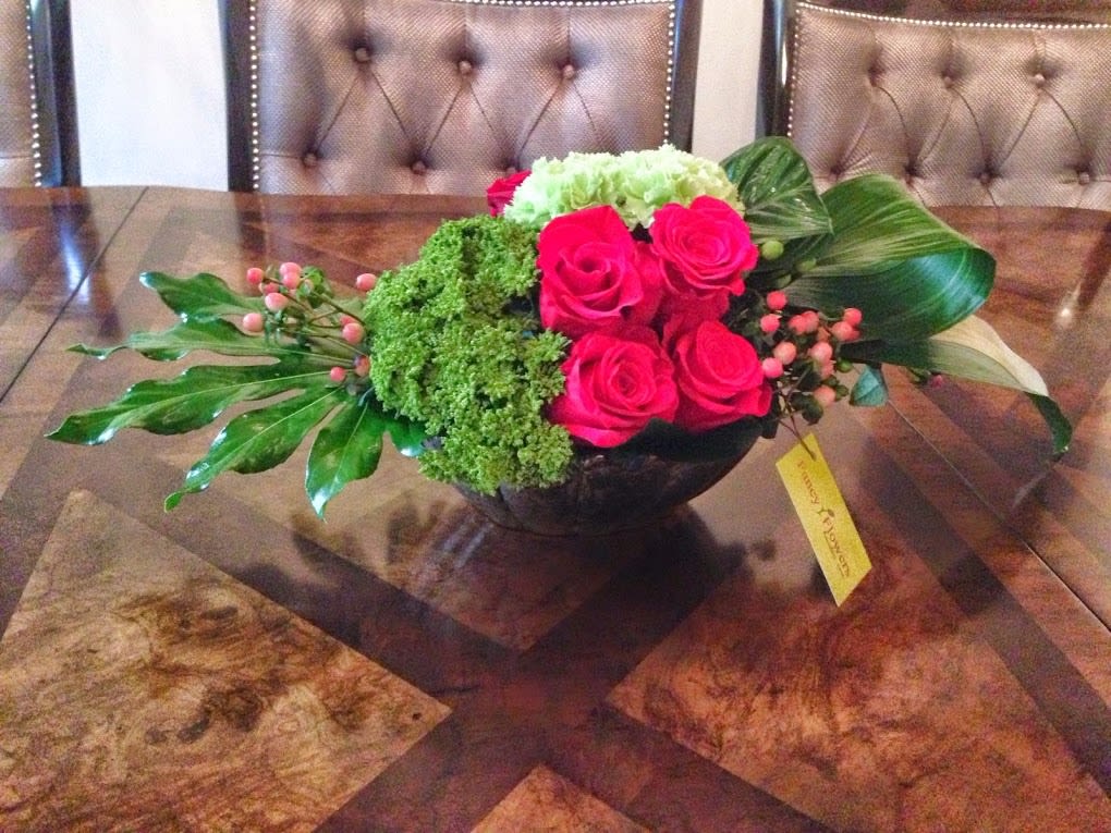 Pink roses and green hydrangea in a low black bowl centerpiece
