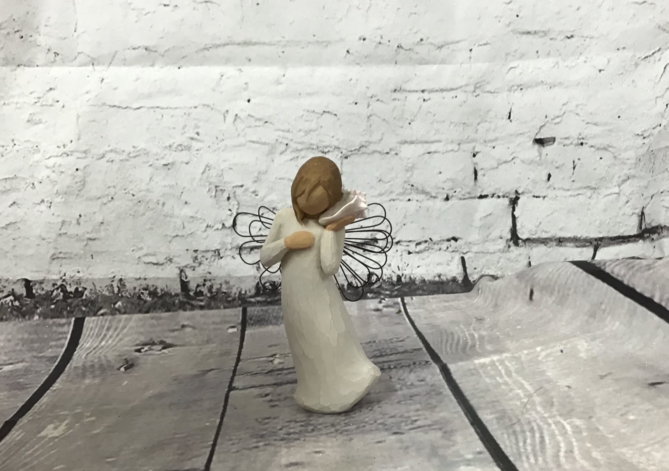 Small angel figurine in a white dress holding a trumpet