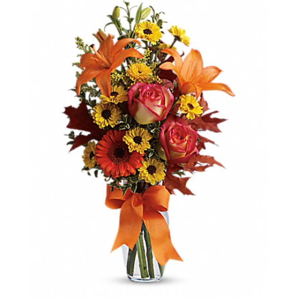 Orange and yellow mixed bouquet in a clear glass vase with a ribbon