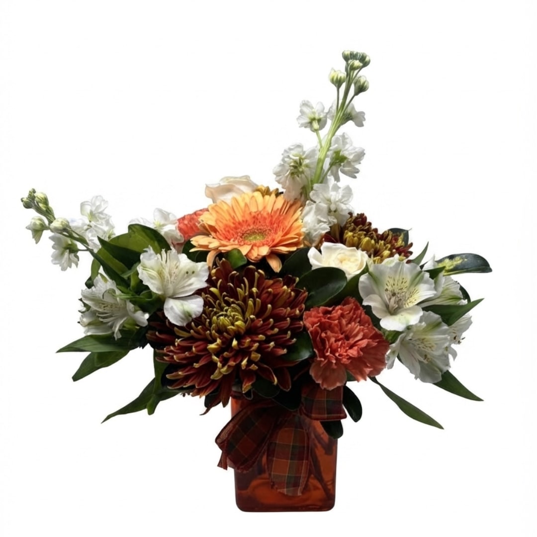 Mixed bouquet in an amber vase with orange, white, and burgundy flowers