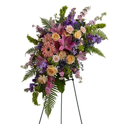 Standing floral spray with pink, purple, and peach blooms on an easel