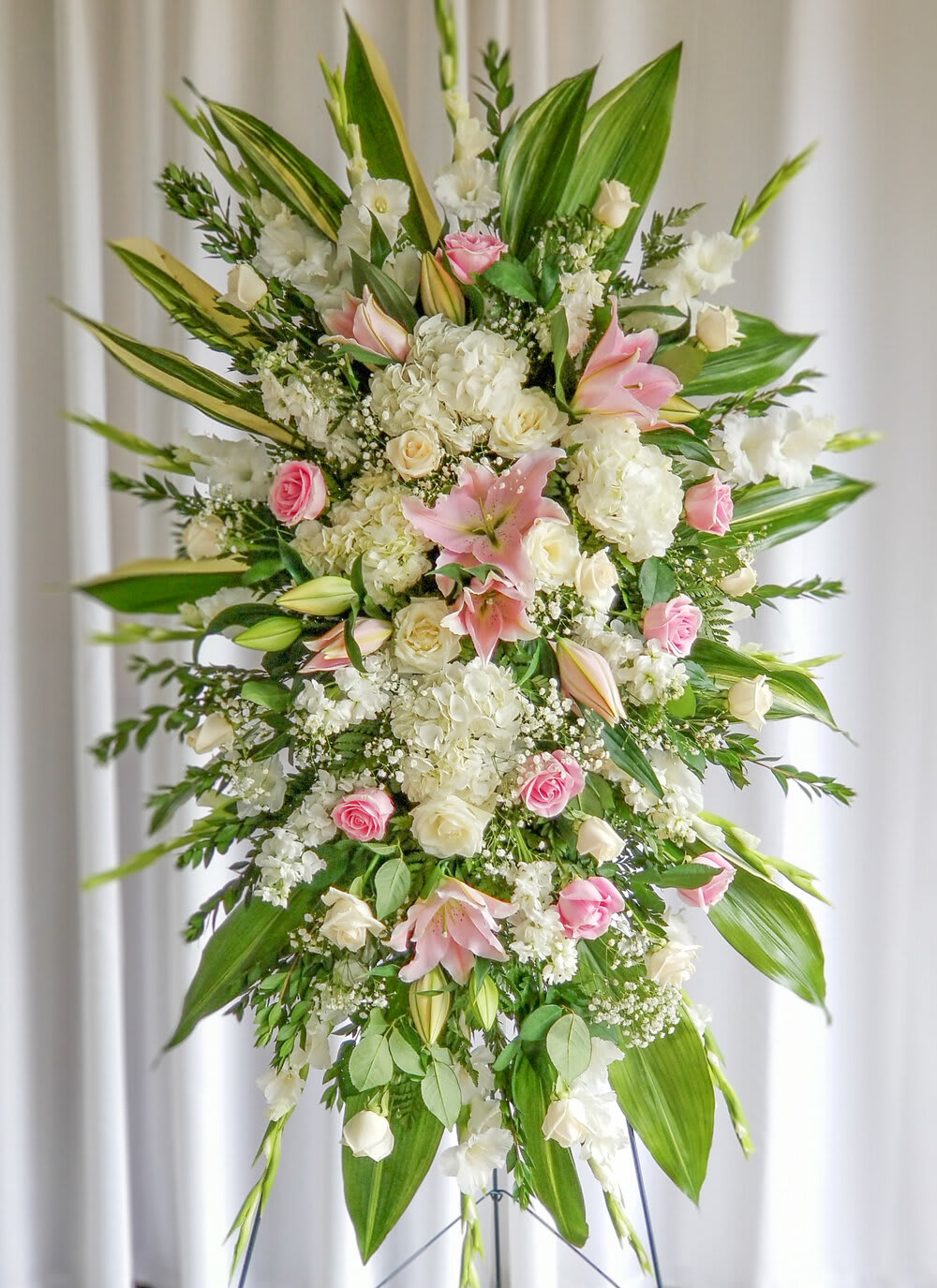 Tall standing floral spray with pink and white lilies and roses