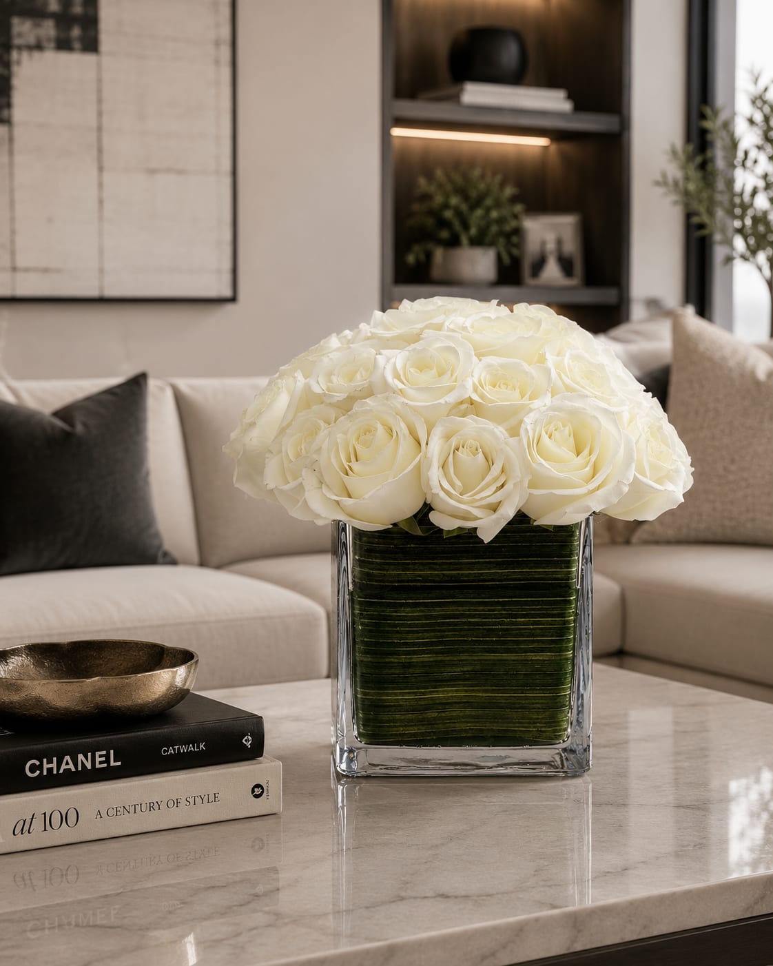 White rose arrangement in a clear square vase on a table