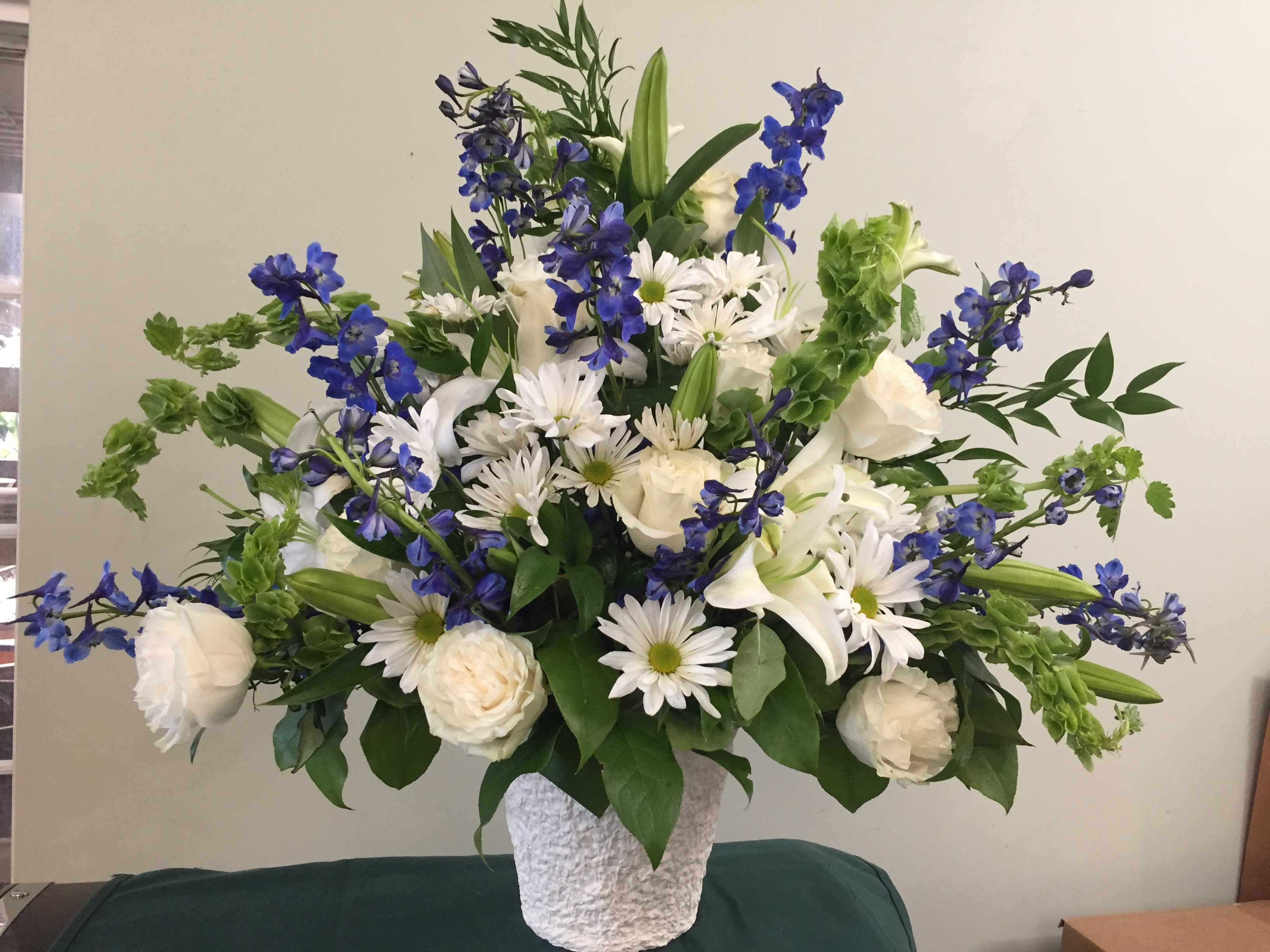 White and blue floral arrangement in a textured white vase