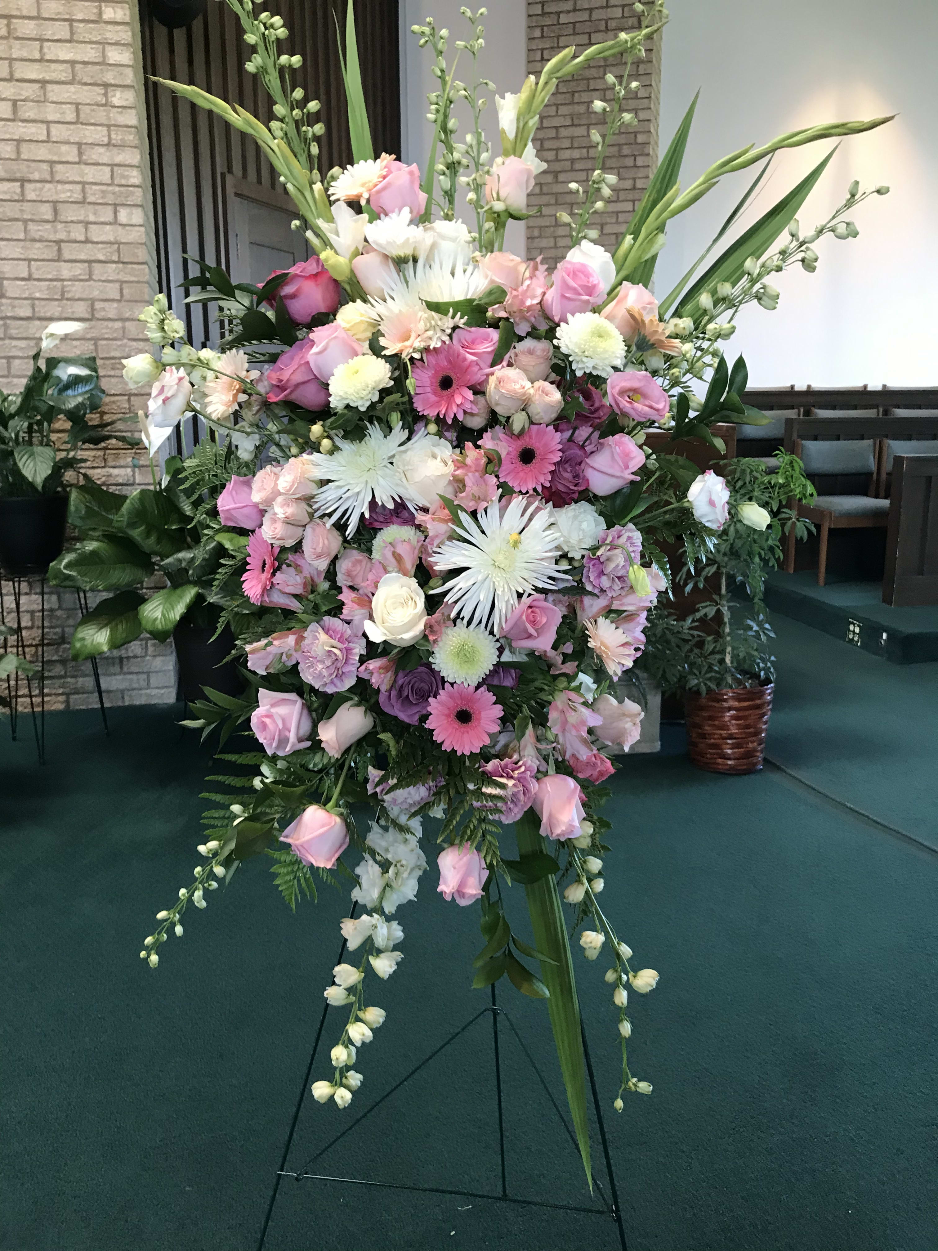 Large pink and white floral standing spray on an easel
