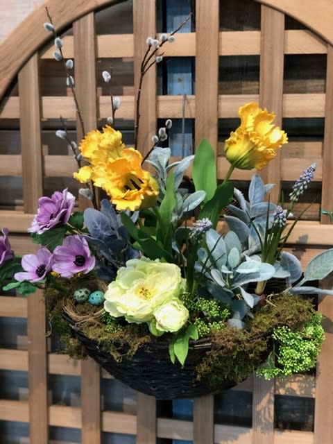 Basket arrangement with yellow and purple flowers and moss