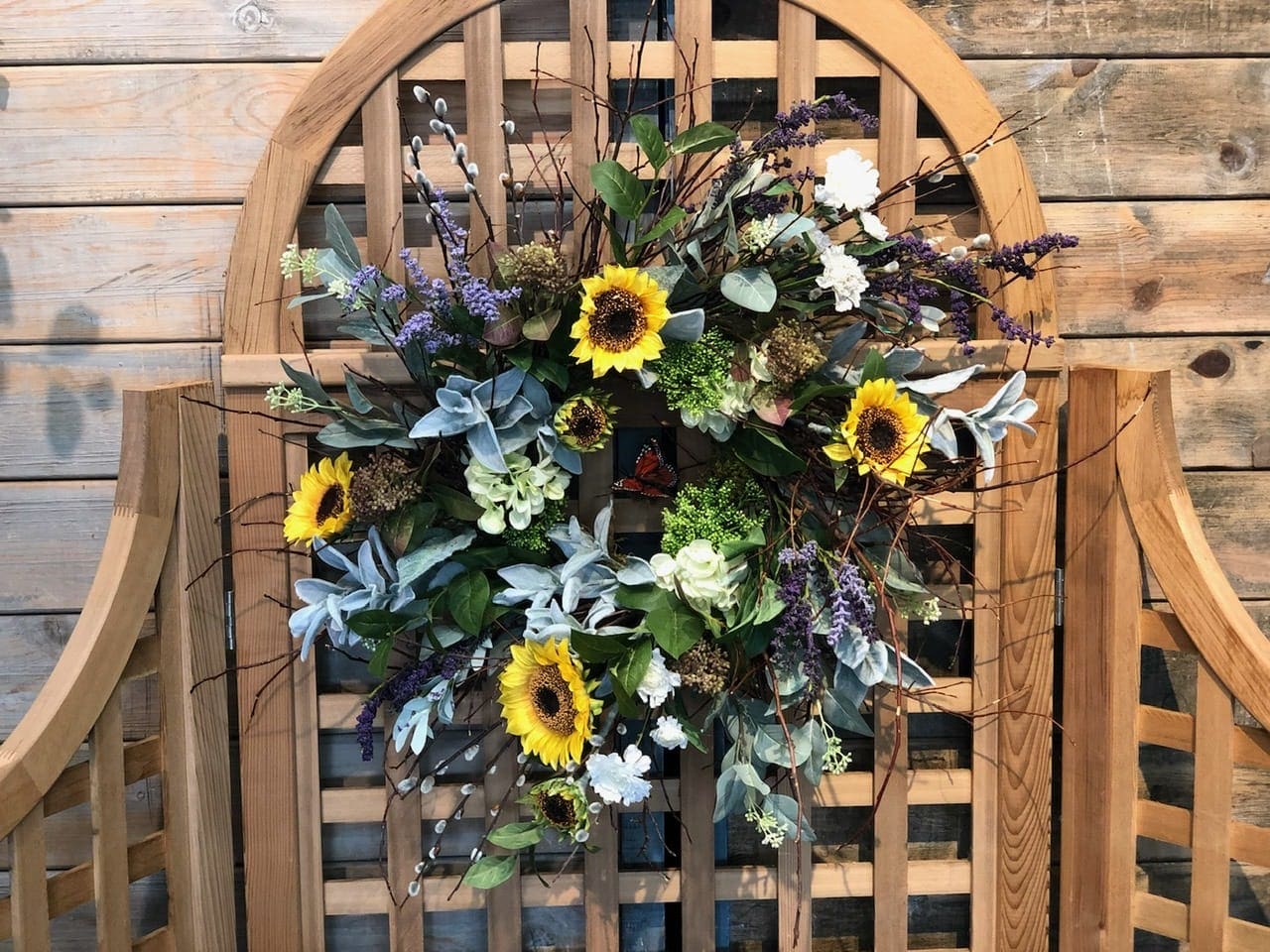 Sunflower wreath with purple accents on a wooden chair back