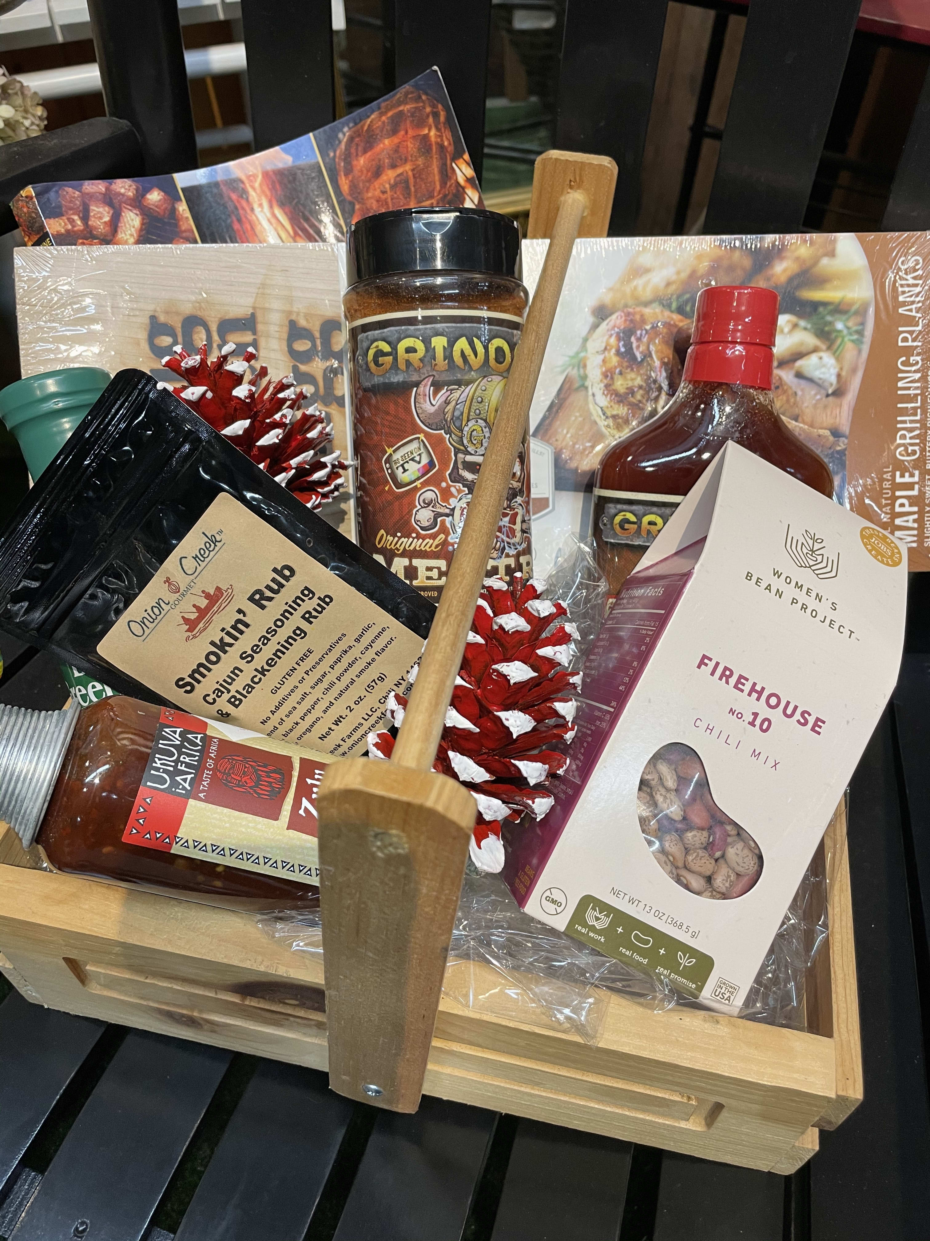 Gift basket with grilling sauces, seasonings, and a wooden utensil