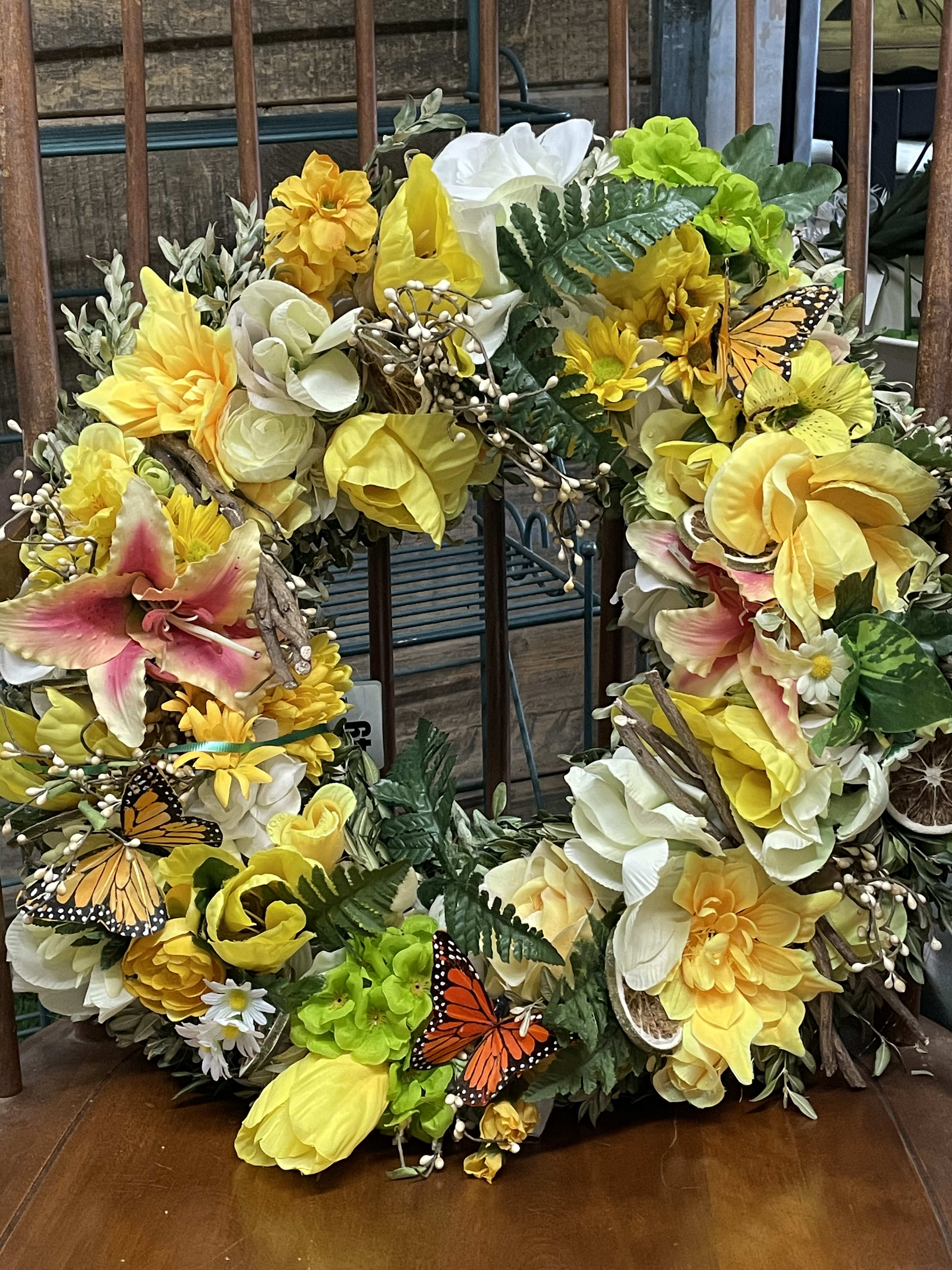 Yellow and white floral wreath with butterflies and greenery