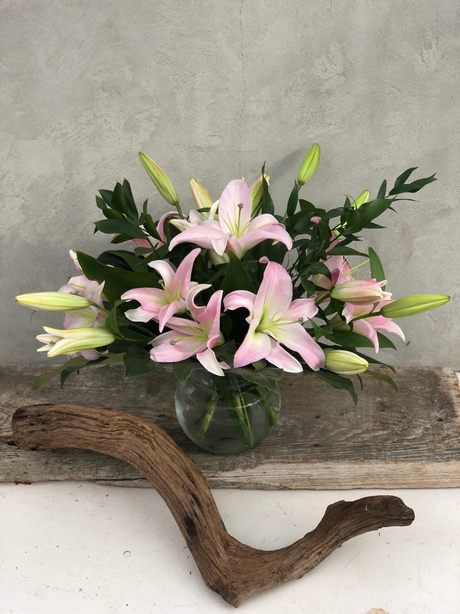 Pink lilies arranged in a clear glass vase