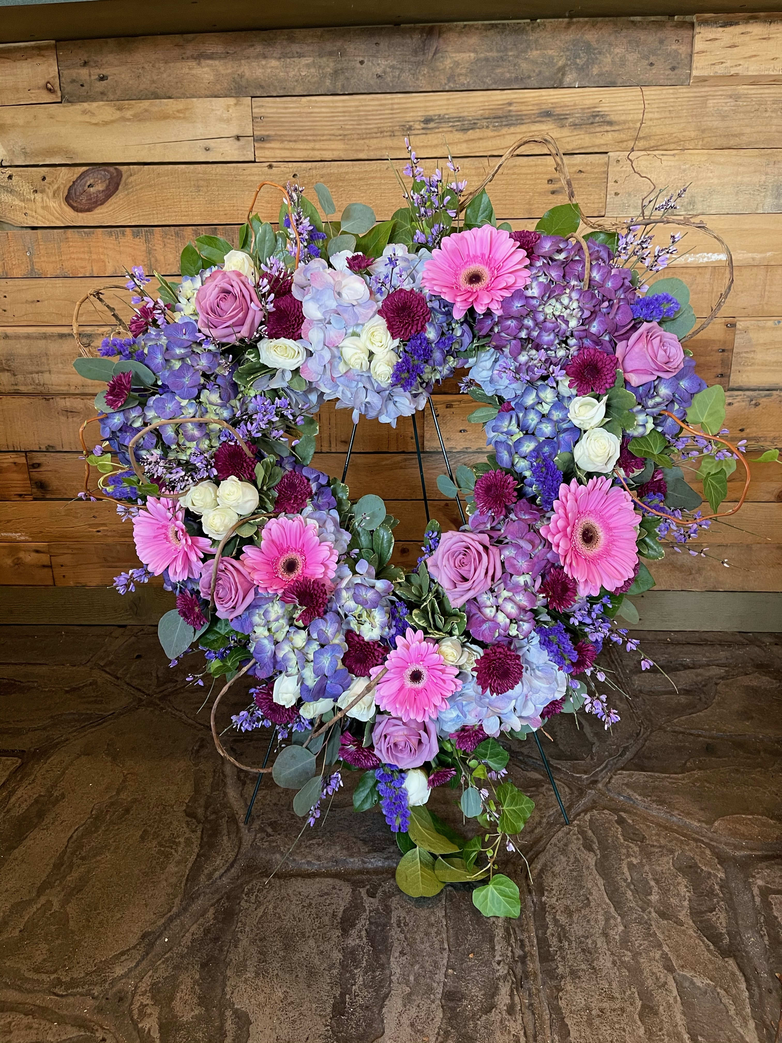 Heart-shaped floral wreath with pink, purple, and white blooms