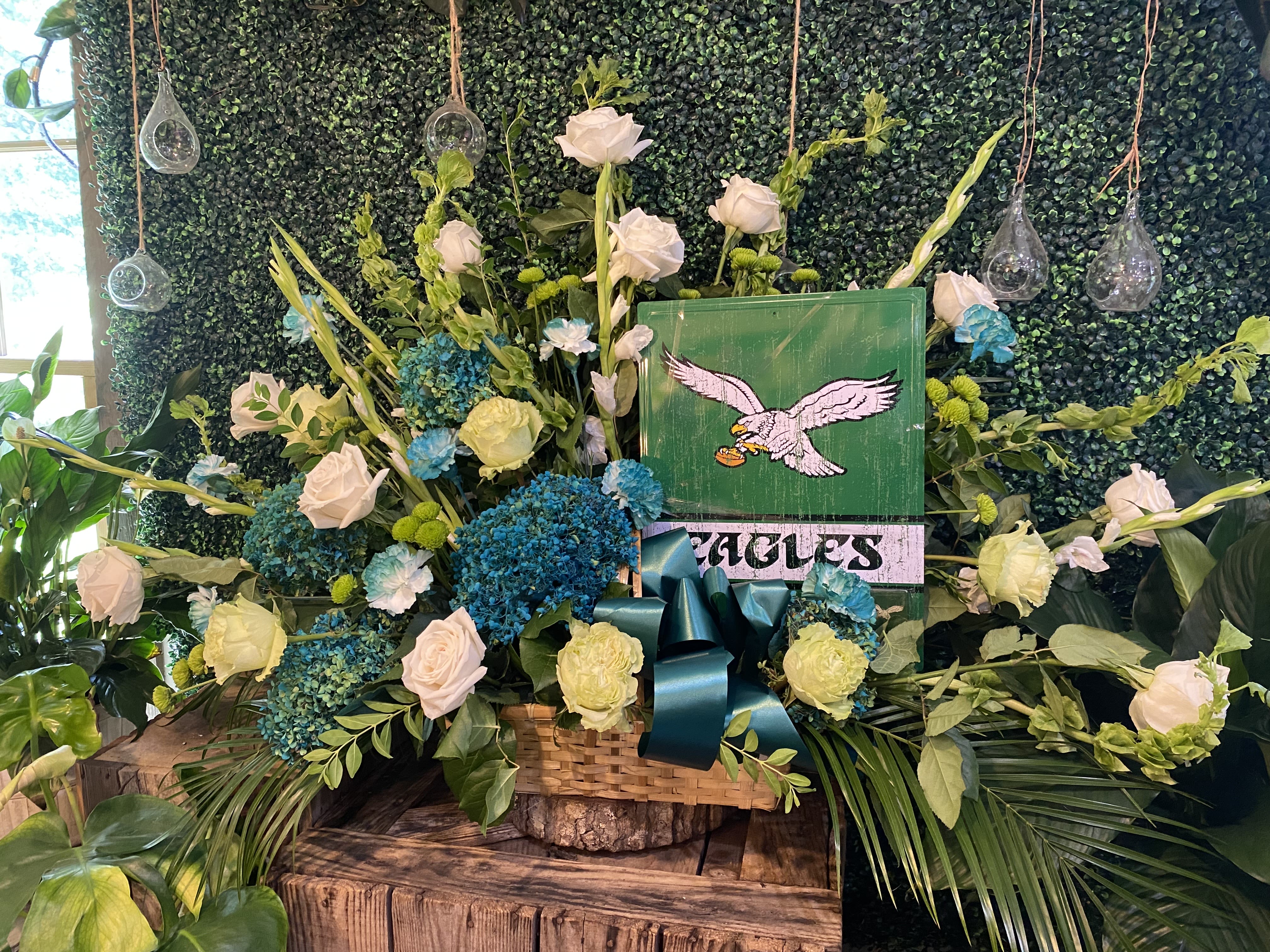 Large floral arrangement with white roses and blue hydrangeas in a basket
