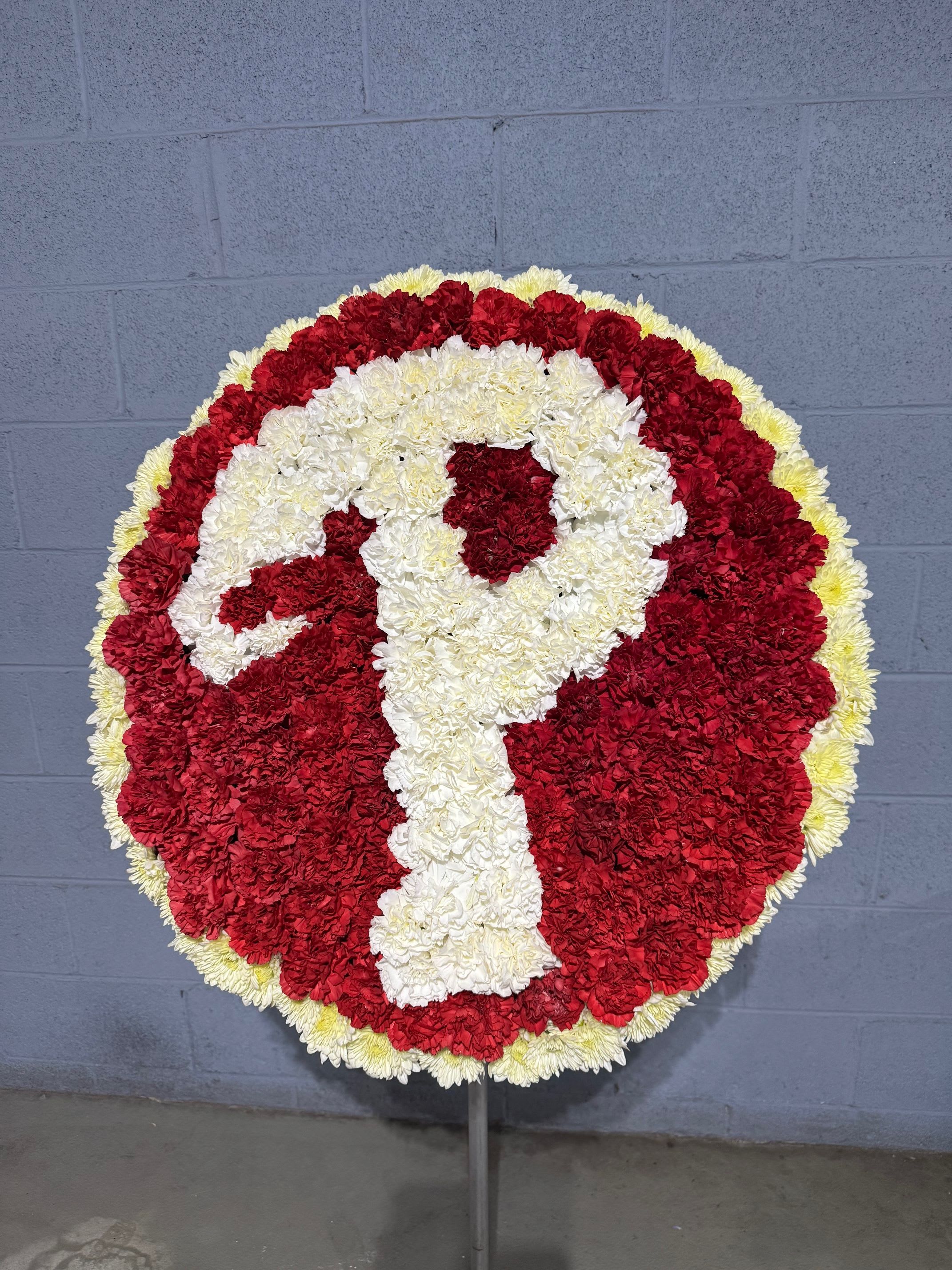 Round red and white floral wreath on a stand