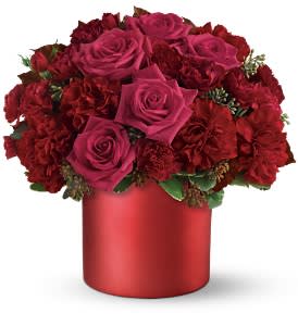 Teleflora's Say it in Scarlet Bouquet - For those who like it hot, this sizzling arrangement of ravishing red favorites in a sleek cylinder vase will get a very warm reception. To fan a flame in someone's heart, you won't find a more passionate choice.  The ravishing arrangement includes hot pink roses, red carnations, red spray roses and hot pink mini-carnations accented with variegated pittosporum and seeded eucalyptus.   Bouquet is approximately 12” W X 12” H  Orientation: All-Around 
