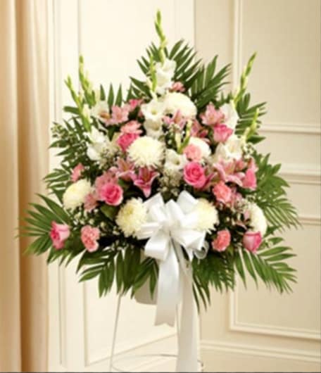Standing floral spray with pink and white flowers and a white ribbon