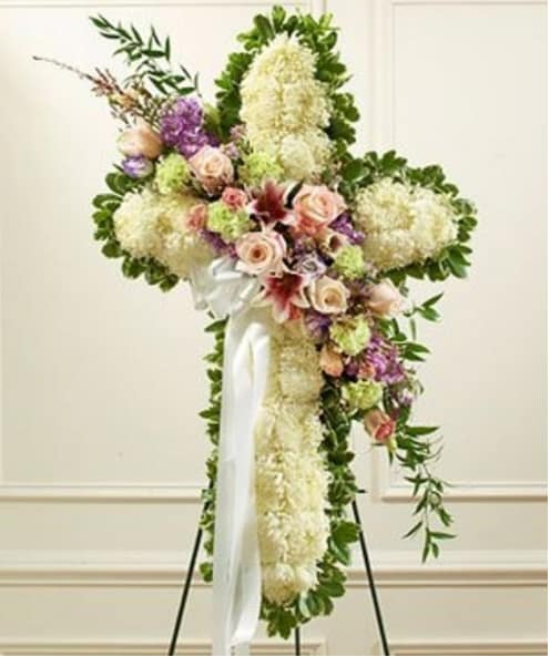 Large floral standing spray with white and pink flowers on a white ribbon