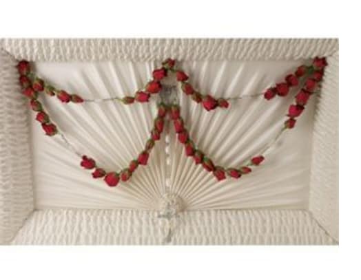 White draped casket with red rose garland