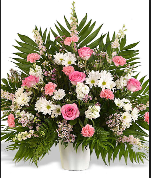 Pink roses and white daisies in a white vase with palm leaves