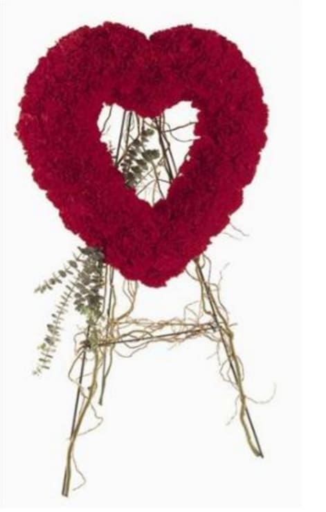Red floral heart-shaped wreath on a stand