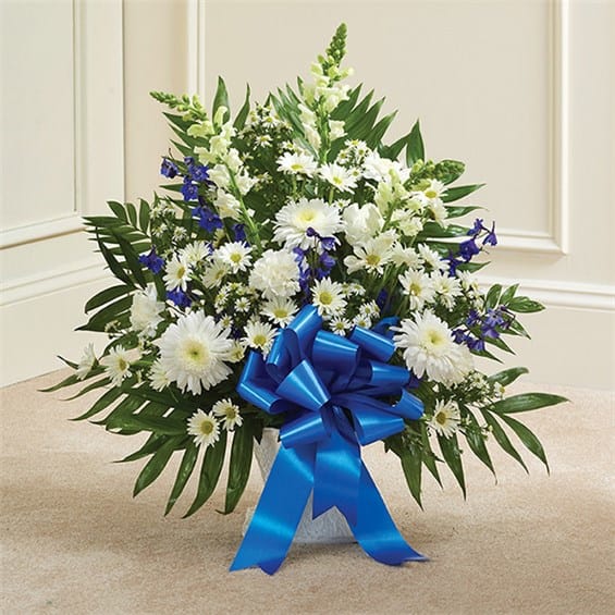White and blue floral arrangement with a large blue ribbon