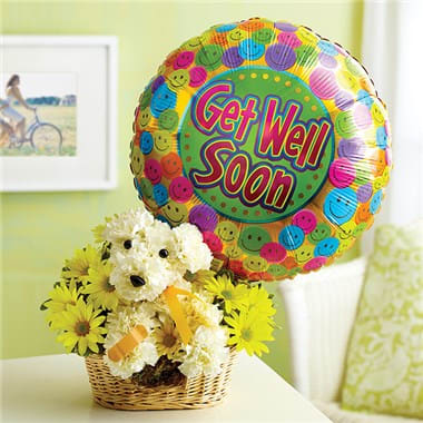 Basket of white and yellow flowers with a get well balloon and teddy bear