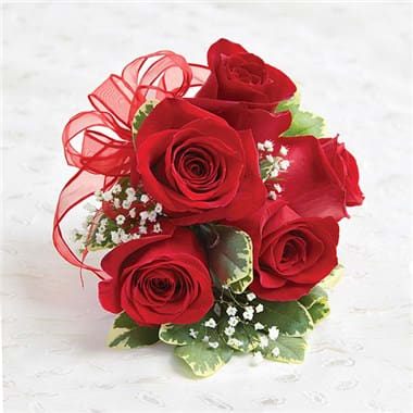 Bouquet of red roses with a red ribbon and small white filler flowers