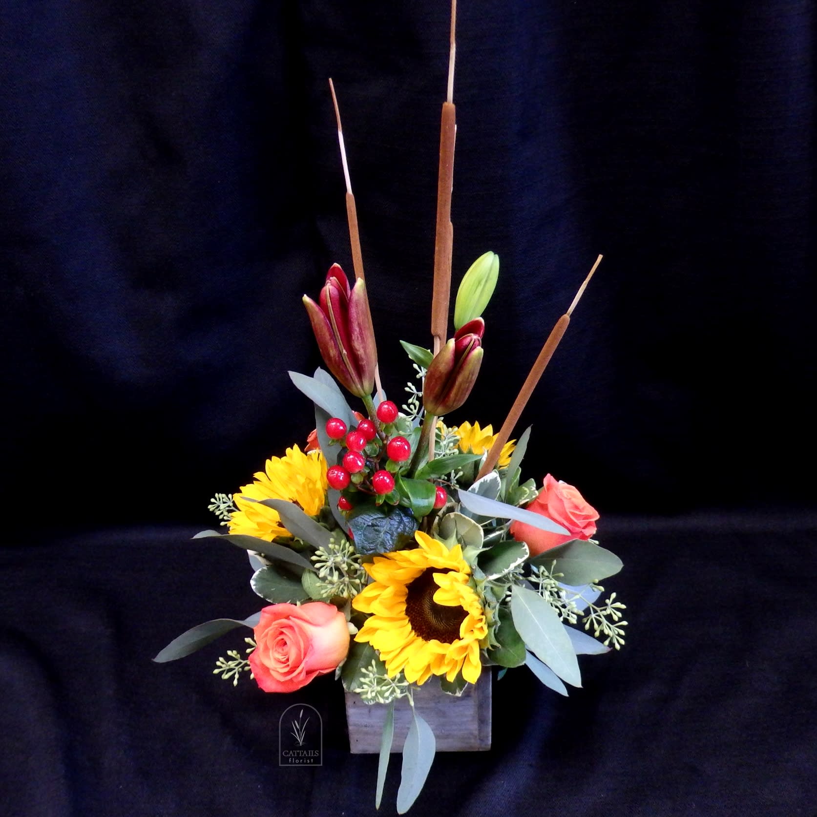 Sunflower and rose arrangement in a wooden box with tall cattails