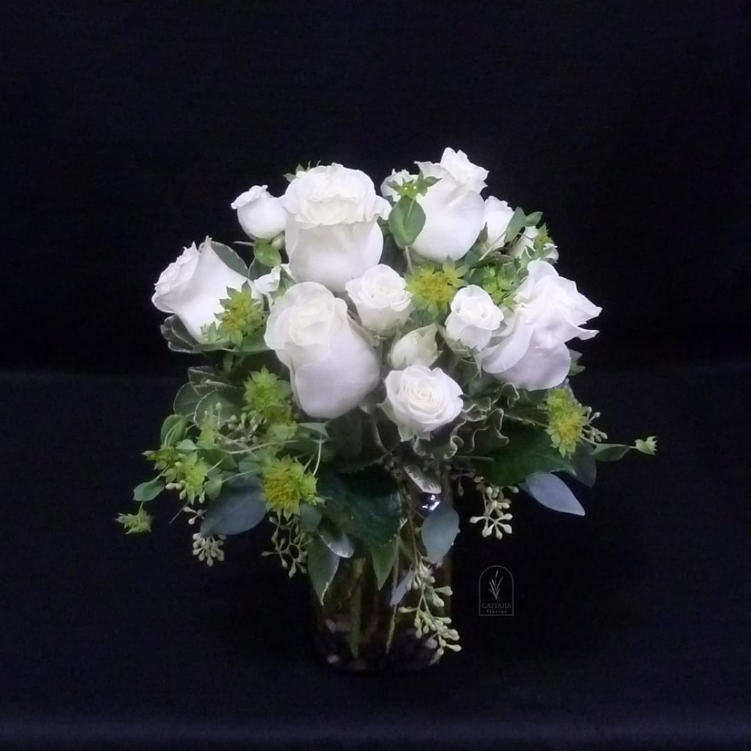 White rose bouquet with green accents on a black background