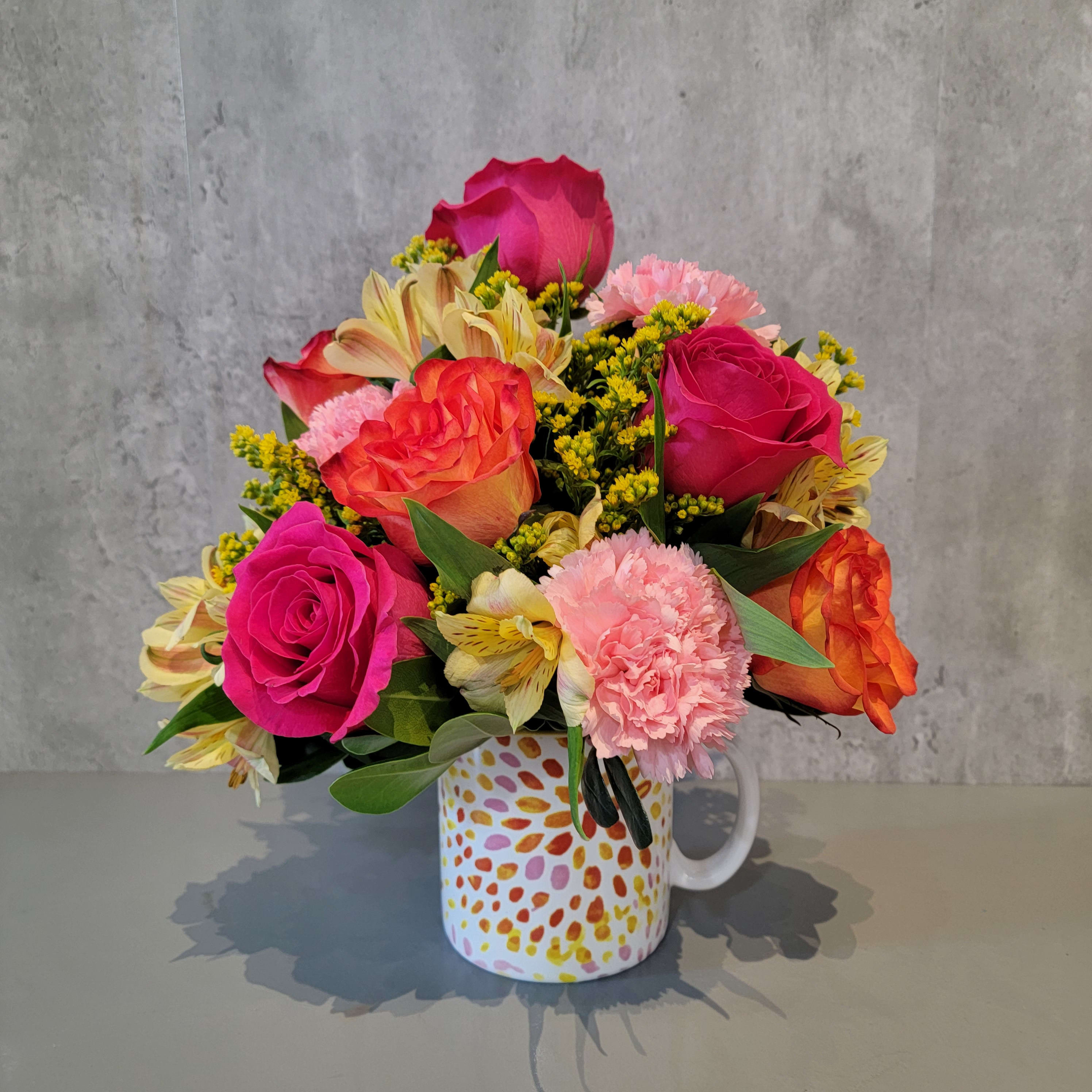 Bright mixed bouquet in a patterned mug vase