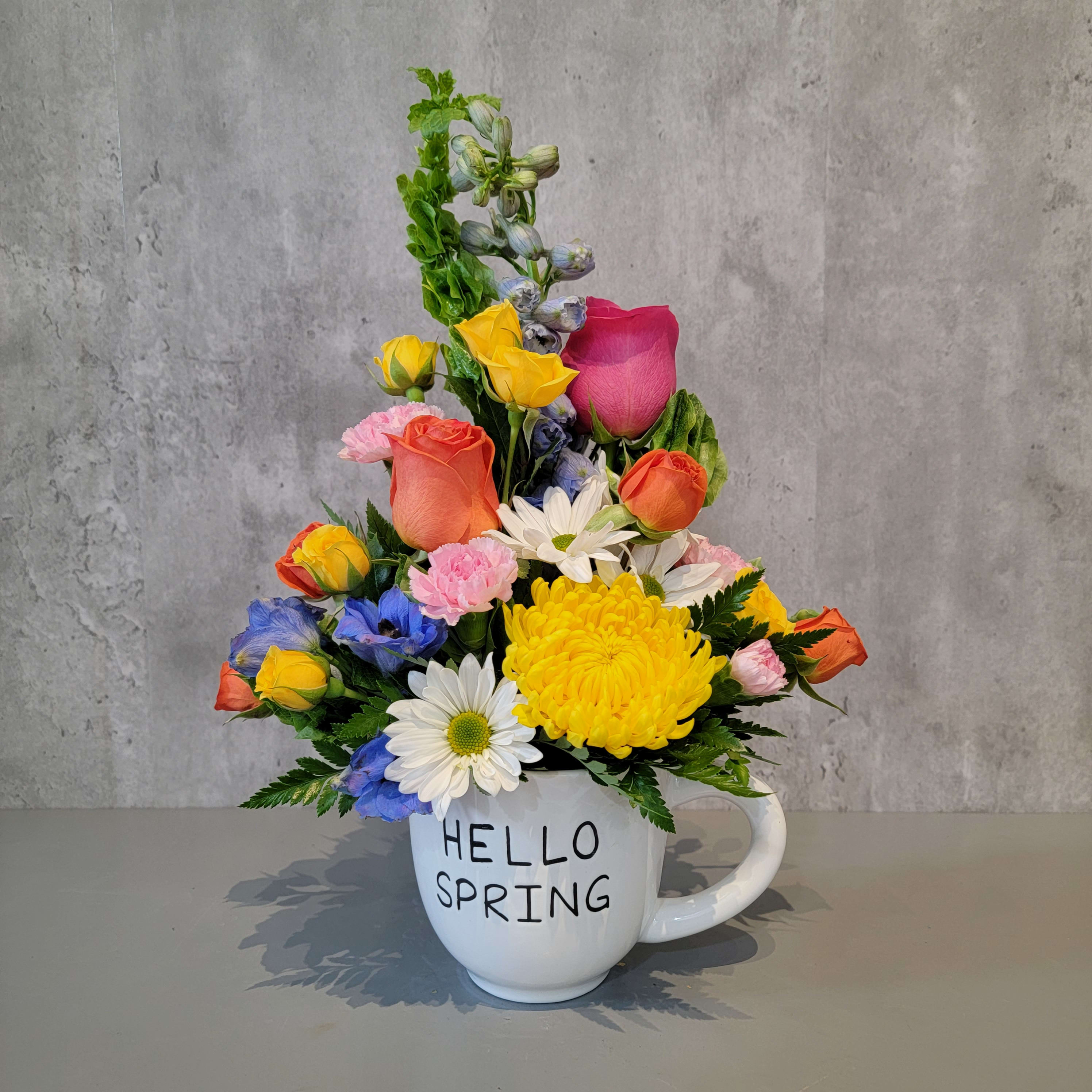 Colorful spring bouquet in a white mug with "HELLO SPRING" text