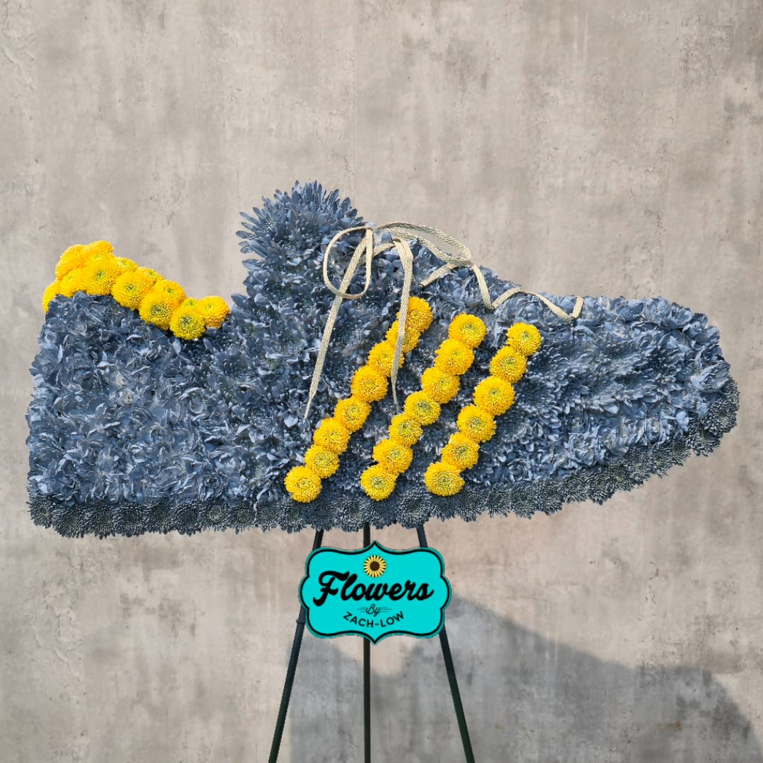 Blue floral standing spray with yellow accents on an easel