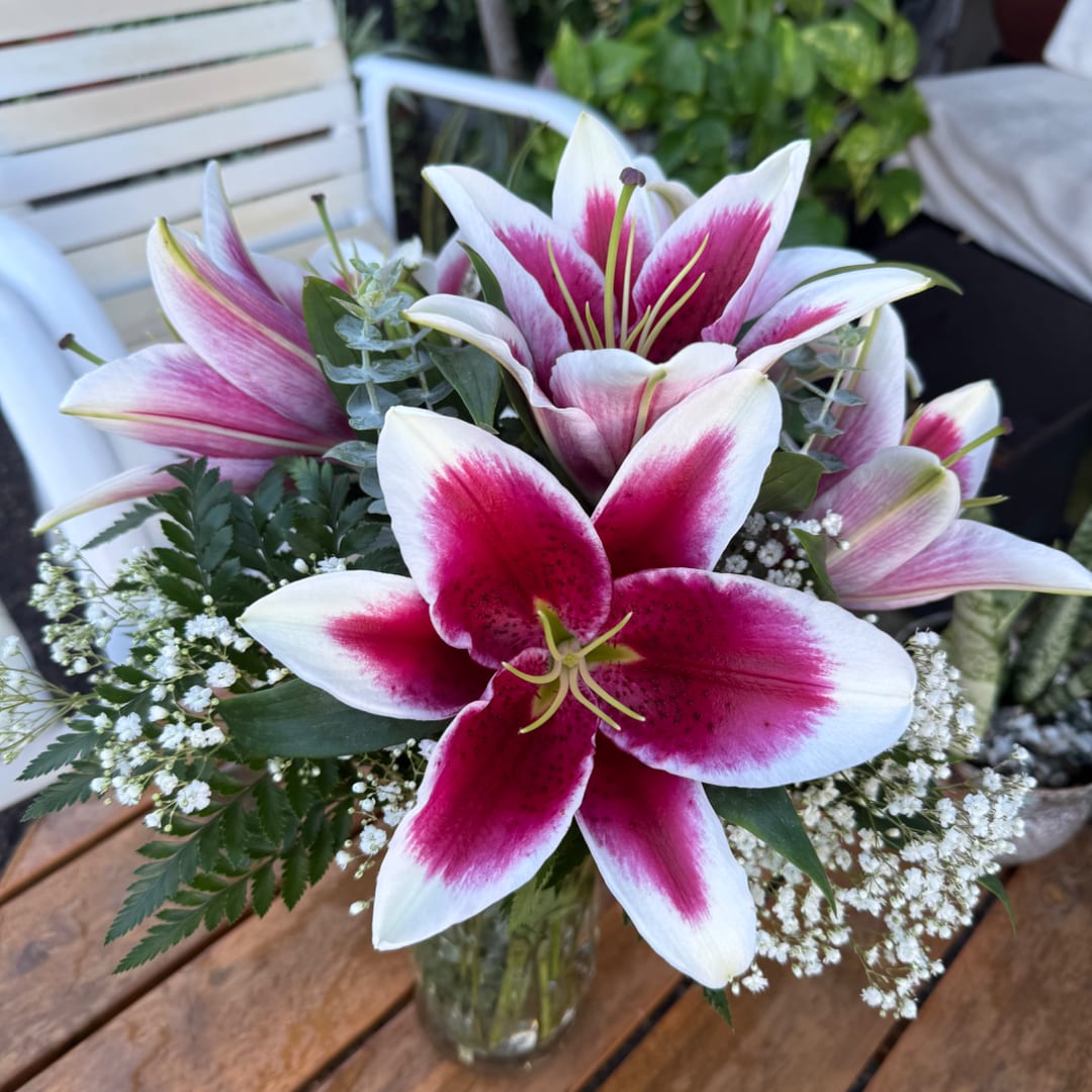 Pink and white lilies arranged in a glass vase