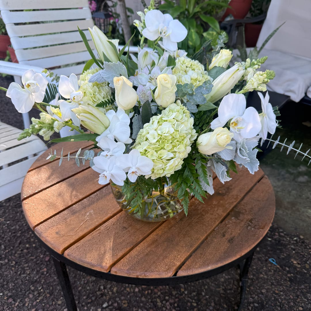 White orchid and rose arrangement in a clear glass vase