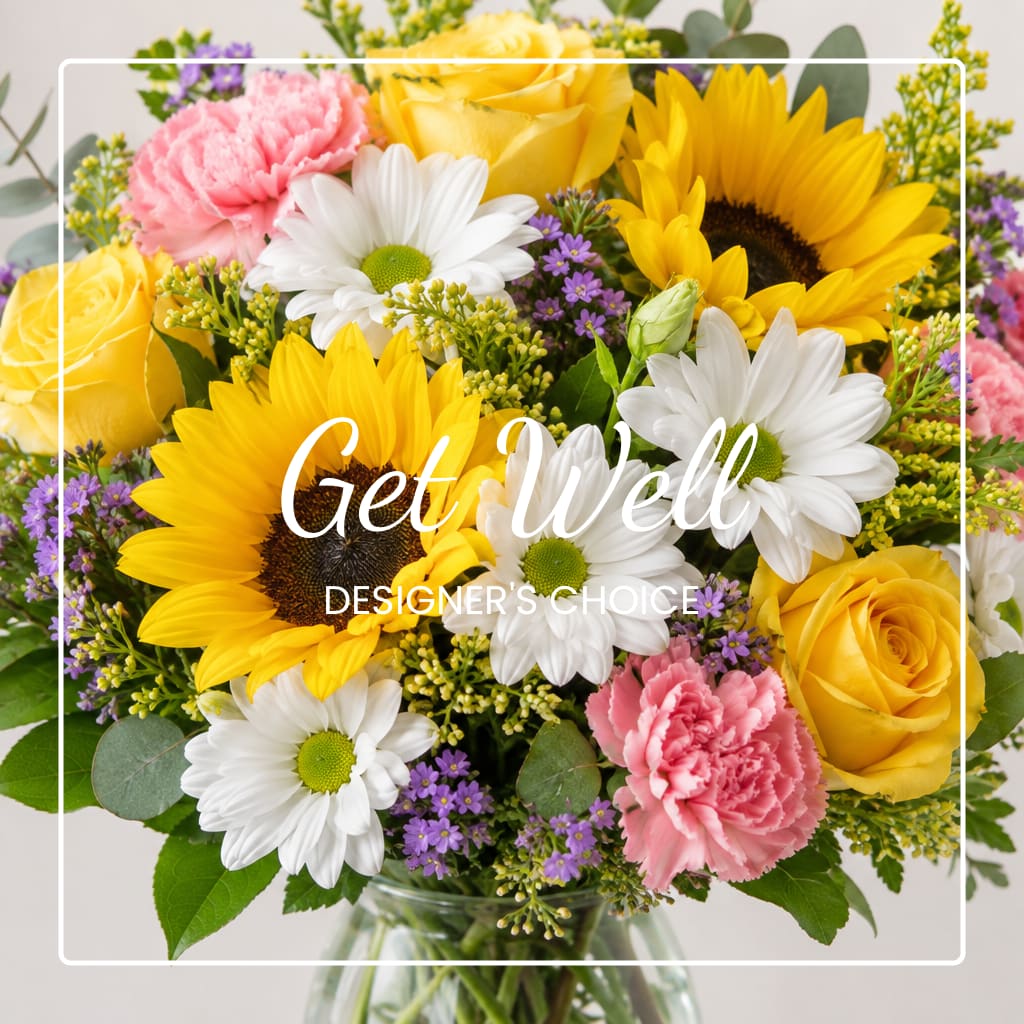 Bouquet of yellow roses, sunflowers, white daisies, and pink carnations in a vase