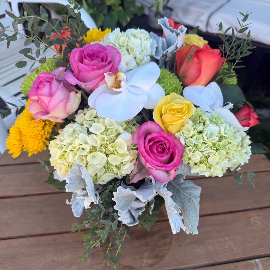 Mixed bouquet of roses, hydrangeas, and orchids in bright colors