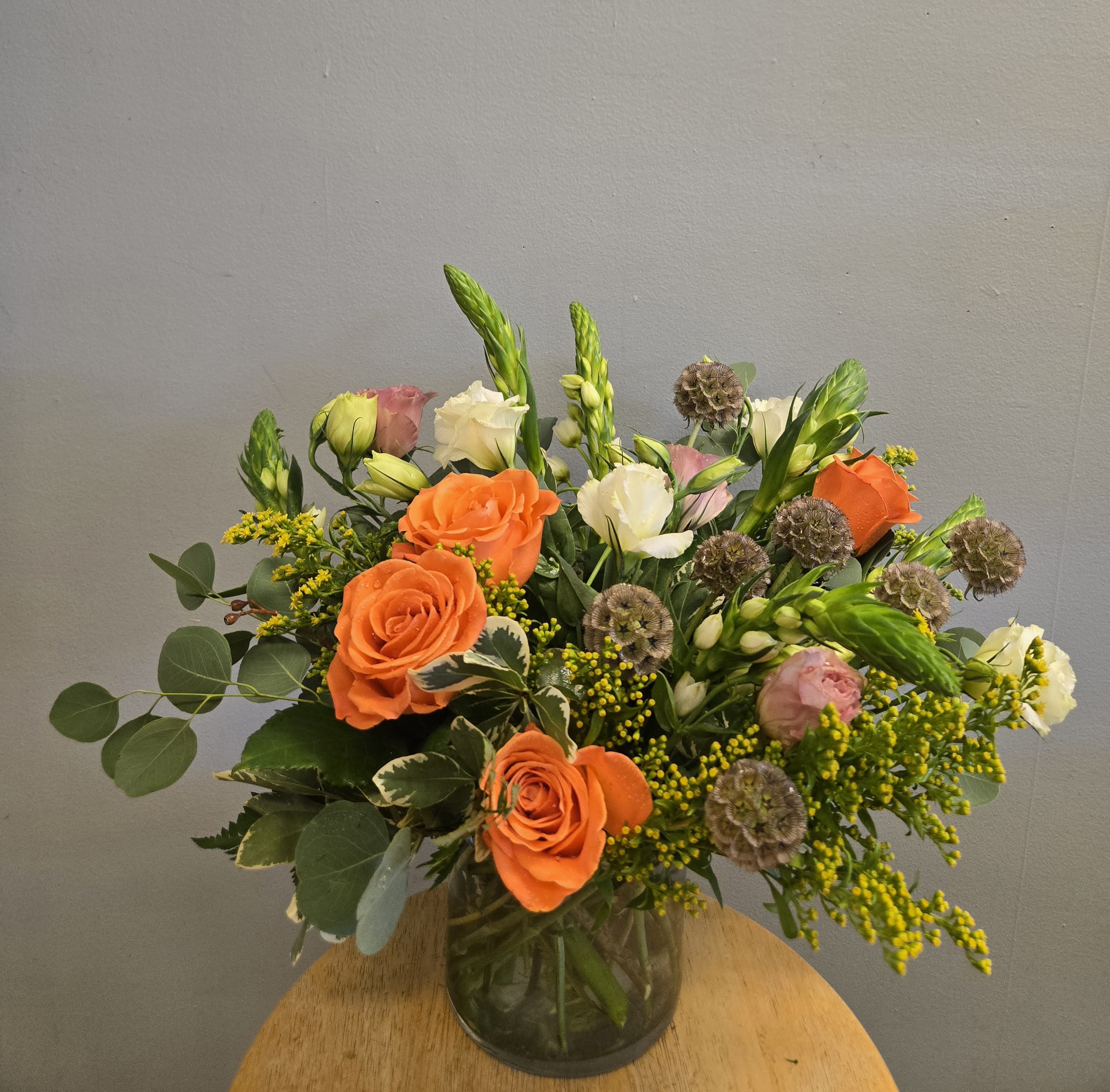 Natural Grace - Bright orange roses take center stage in this garden-style flower arrangement, a cheerful bouquet perfect as a birthday bouquet, thank-you gift, or a just-because surprise. The combination of orange, white, and blush-pink blooms reads bright and uplifting; the recipient will feel noticed and celebrated the moment these colors catch their eye.   