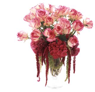 Pink roses and red hanging flowers in a clear vase