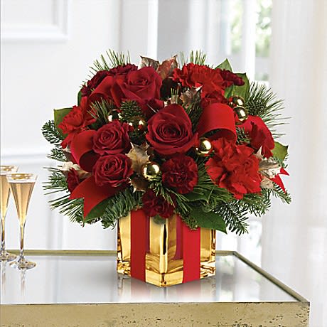 Red roses and carnations in a gold gift box with ribbon