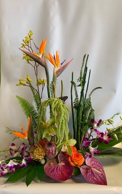 Tropical flower arrangement with orange bird-of-paradise and purple orchids
