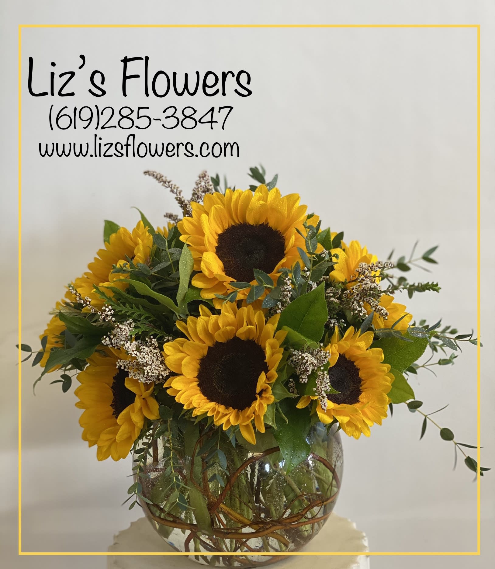 Sunflower arrangement in a round glass vase