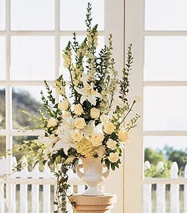 Tall white floral arrangement in a pedestal vase