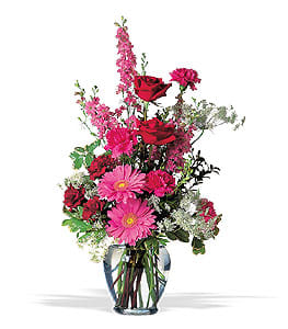 Pink and red mixed flower arrangement in a glass vase