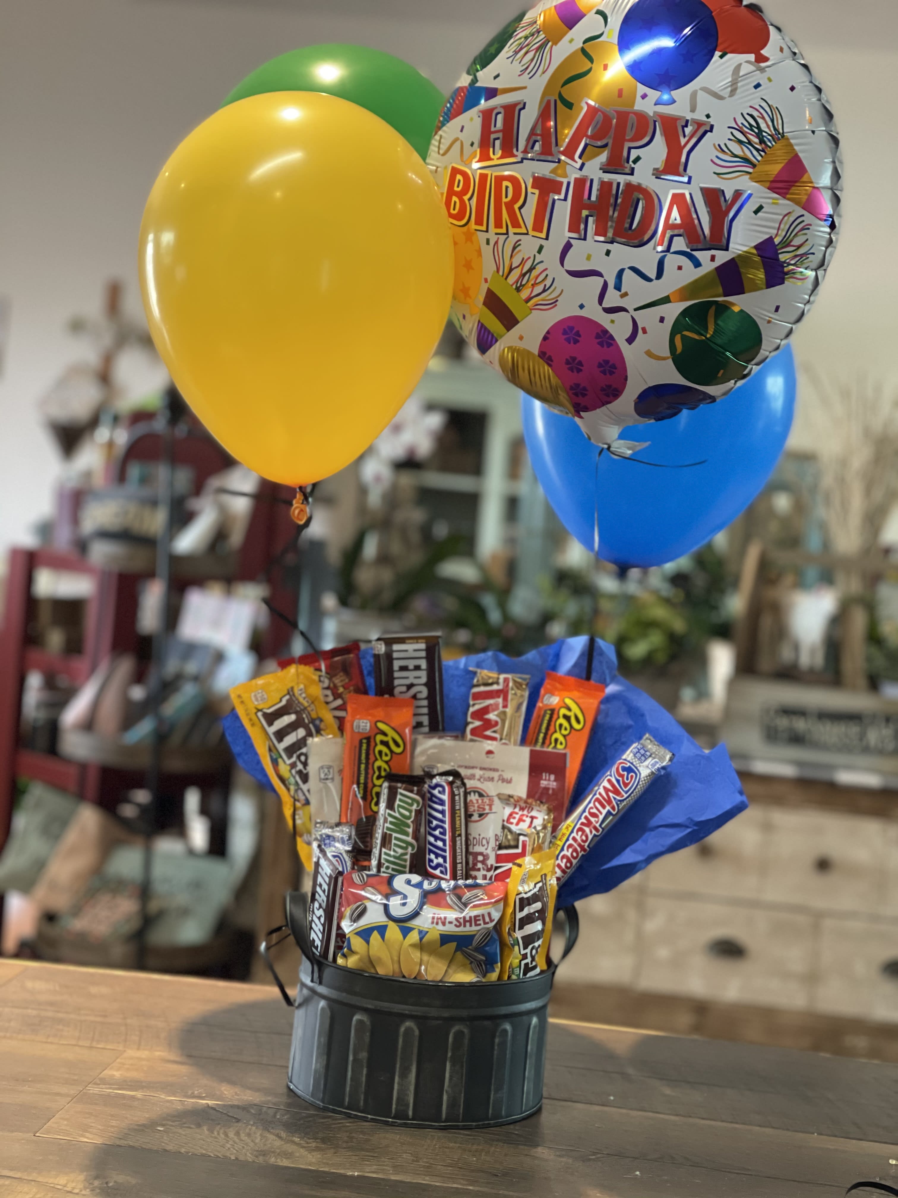 Birthday balloon bouquet with candy bars in a black container