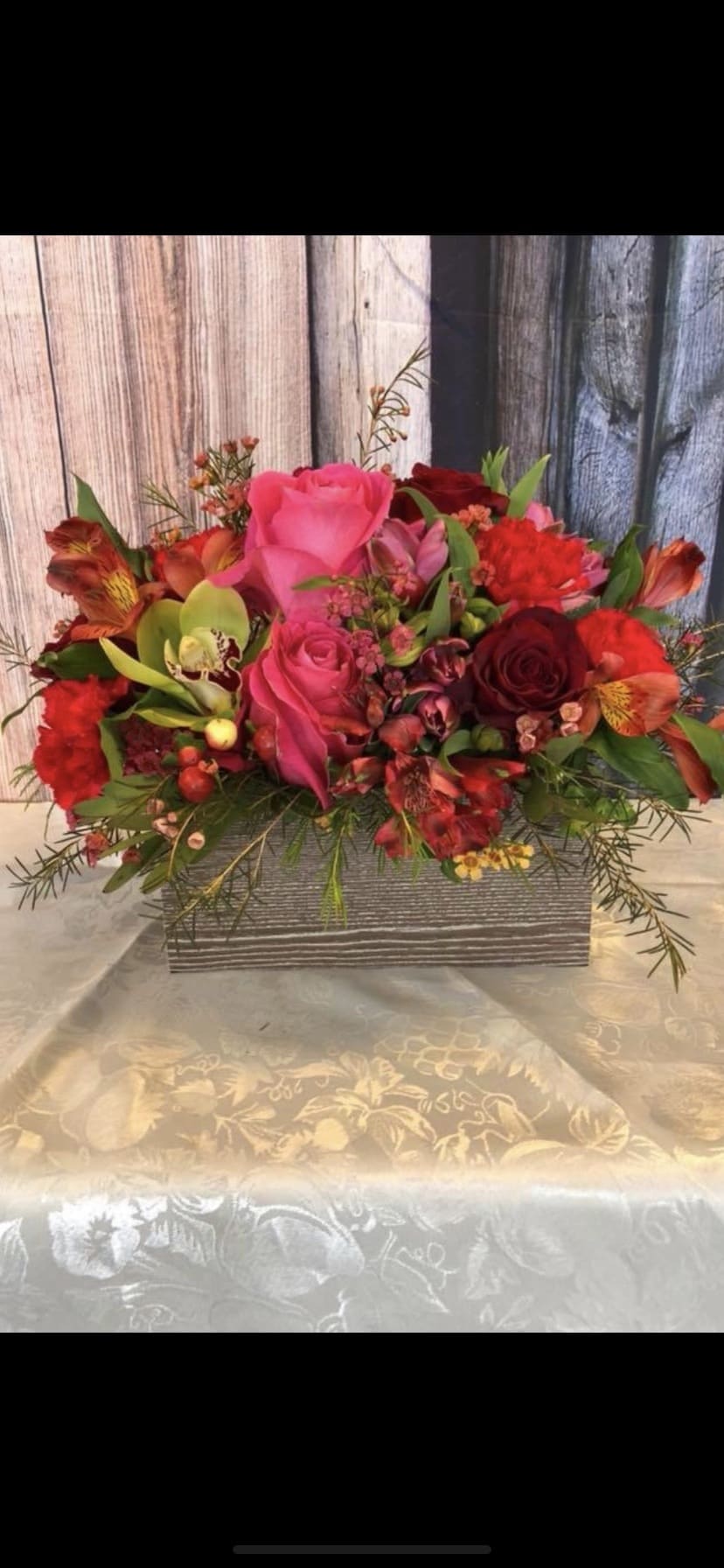 Mixed bouquet of pink and red flowers in a rectangular box