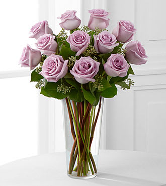 The FTD® Lavender Rose Bouquet - E3-4811S  An enchanting bouquet of lavender roses sweetly touches her heart. Paired with seeded eucalyptus in a stylish glass vase, these lovely roses are a perfect gift. 