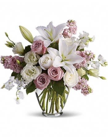 Bouquet of white lilies and pink roses in a clear glass vase